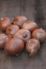 Shallots onions on vintage wooden board