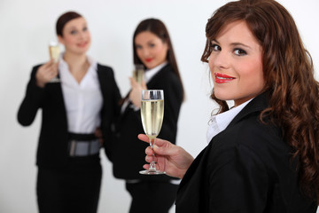 Suited women drinking champagne