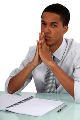 Naklejka premium Young businessman with a pad and pen