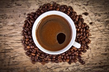 White coffee cup with beans on rustic wooden table