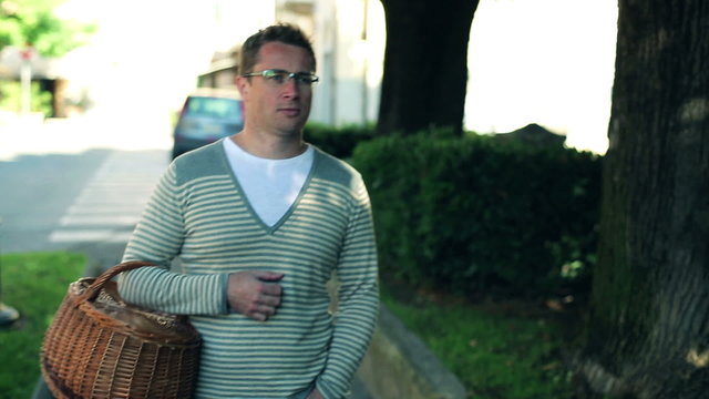 Man with basket walking along the street in the city, steadycam 