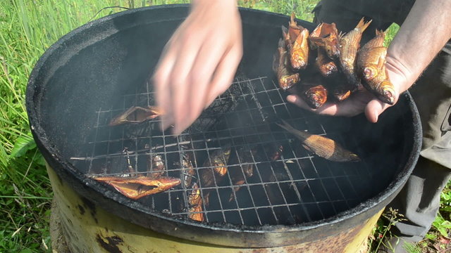 hand take fresh delicacy smoked fish from smokehouse