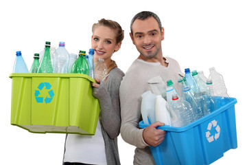 Couple recycling empty plastic bottles - obrazy, fototapety, plakaty