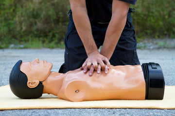 Male instructor showing CPR on training doll