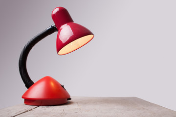 isolated red lamp on wooden desk