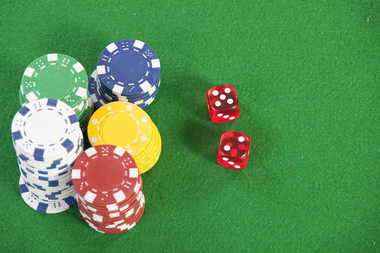 red dice on a casino table with chips  