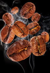 Flying coffee beans in smoke, isolated on black background