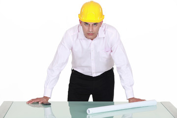 architect with determined gaze and arms resting on glass table