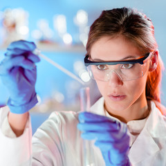 Attractive young scientist pipetting.