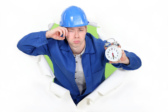 Bleary Eyed Construction Worker With An Alarm Clock