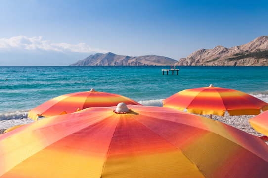Orange Sunshades on beach at baska - Krk - Croatia
