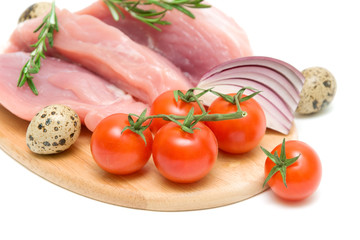 cherry tomatoes, raw meat, eggs, onions and a sprig of rosemary