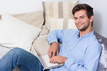 Young man using laptop on couch