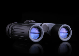 Modern compact binoculars over black background