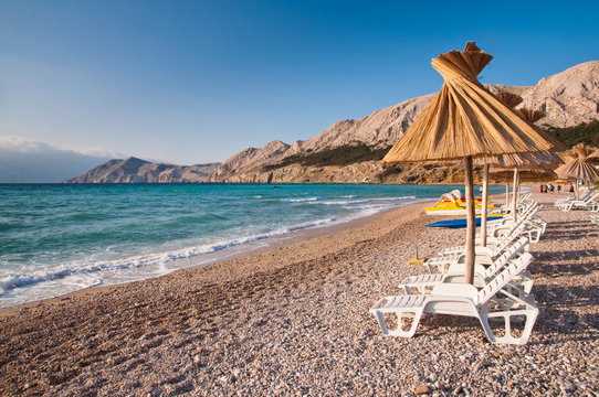 Sunshade and deck chair on beach at Baska in Krk - Croatia