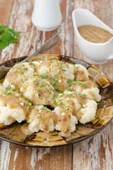 boiled cauliflower with sauce closeup vertical