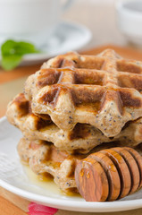 homemade waffles with maple syrup and poppy closeup