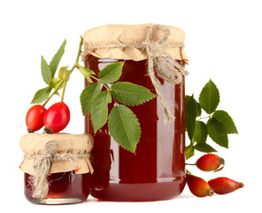 jars with hip roses jam and ripe berries, isolated on white