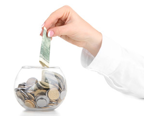 Woman hand with money in glass jar isolated on white