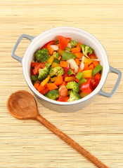 Vegetable stew in gray pot on bamboo mat background