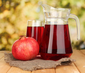 Full glass and jug of pomegranate juice and pomegranate