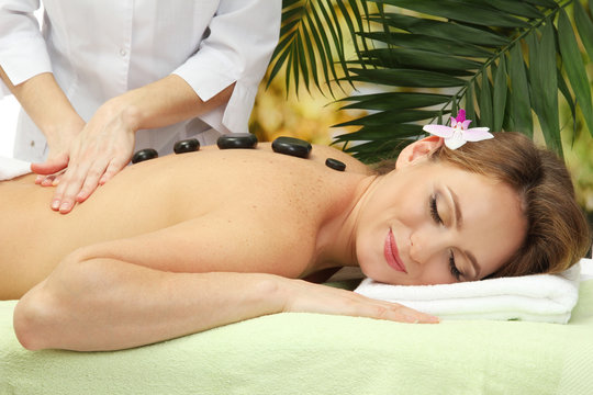 beautiful woman in spa salon  getting massage with stones,