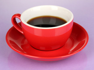 A red cup of strong coffee on purple background