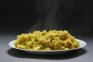Rice with vegetables and curry in plate on neutral bacground