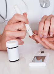 Doctor testing a patients glucose level