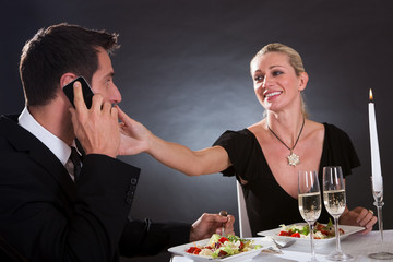Man taking a mobile call during dinner