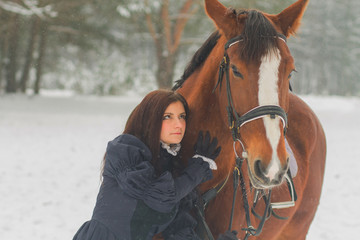 Beautiful woman and horse in winter