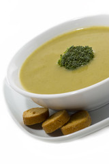 Cream broccoli soup with dried crusts isolated on white