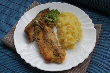 Baked white fish and mashed potatoes on grey linen cloth