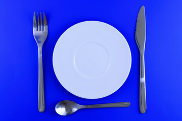 Table serving-dishware on colour backdrop.