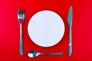 Table serving-dishware on red backdrop.
