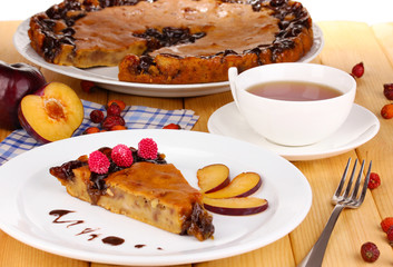 Tasty pie on plate on wooden table