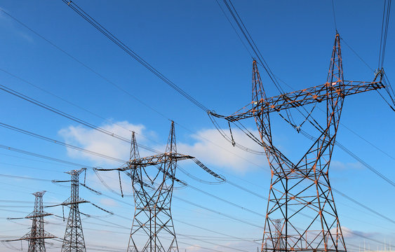 four power high voltage tower over blue sky