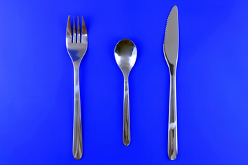 Table serving-dishware on colour backdrop.