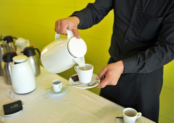 Camarero sirviendo café con leche, servicio de catering