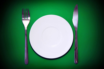 Table serving-dishware on green backdrop.