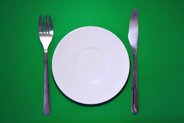 Table serving-dishware on green backdrop.