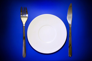 Table serving-dishware on colour backdrop.