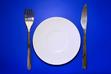 Table serving-dishware on colour backdrop.
