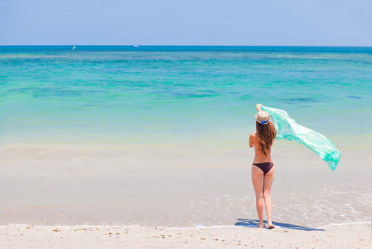 beautiful woman in a bikini and pareo on tropical beach