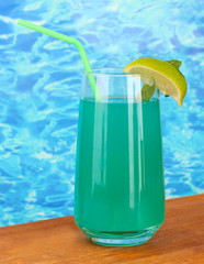Glass of blue cocktail on blue background