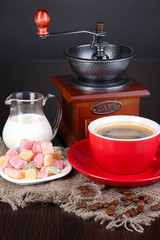 Red cup of coffee with rahat delight, milk and coffee mill