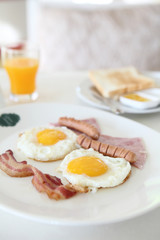 Breakfast with bacon , fried egg and orange juice