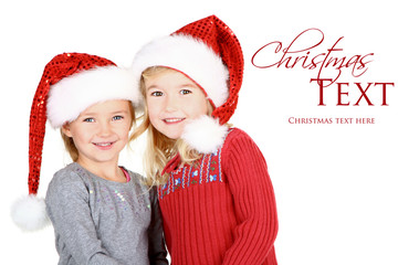 Two children wearing Santa hats