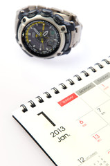 Wrist watch on the calendar background