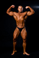 A male bodybuilder flexing his muscles.